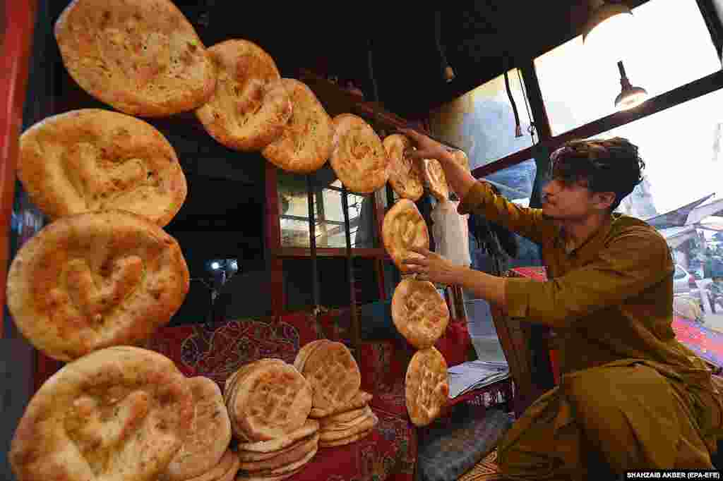 Një burrë duke nxjerrë në shitje simite tradicionale afgane, të njohura si nan, në Karaçi, Pakistan. Shitjet e nanit afgan kanë rënë ndjeshëm nëpër lagje, pasi afati i vendosur nga qeveria pakistaneze për dëbimin e imigrantëve afganë pa dokumente skadoi më 1 nëntor, ndërsa mijëra refugjatë u kthyen në atdheun e tyre.