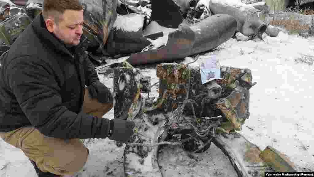 Dmitro Csubenko, a harkivi ügyészség munkatársa egy ballisztikus rakéta darabja mellett térdel, amelyet Ukrajna szerint Észak-Koreában gyártottak, Oroszországnak szállítottak és Ukrajnába lőttek. Mihajlo Podoljak ukrán elnöki tanácsadó január 5-én csatlakozott az Egyesült Államokhoz, amikor azt állította, hogy Oroszország teljes körű inváziójának megindítása óta először Észak-Korea által szállított rakétákkal csapott le Ukrajnára