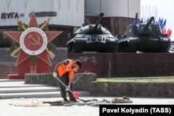 Un angajat municipal repară trotuarul de lângă monumentul dedicat celui de-Al Doilea Război Mondial, în perioada premergătoare sărbătoririi Zilei Victoriei, la Belgorod, pe 5 mai.