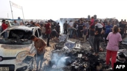 Palestinezët mblidhen në vendin ku një sulm ajror izraelit e goditi një kamp të të zhvendosurve brenda vendit në Rafah, 27 maj 2024.