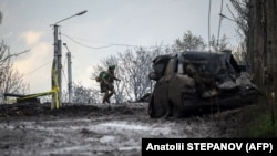 Ukrajinski vojnik bježi u zaklon od granatiranja preko ulice u gradu Bakhmut na liniji fronta 23. aprila