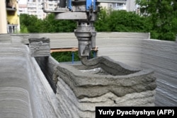 Një grykë printimi që vendos përzierjen e betonit në vendin e ndërtimit në Lviv.