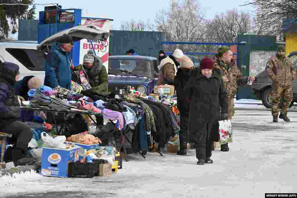 Цивільні та військові купують усе необхідне на ринку в Куп'янську, 13 лютого 2023 року. 62-річна Ольга розповідає, що також хотіла б виїхати, але повинна залишитися і доглядати за своїм 37-річним сином-інвалідом. «Кожен день лунають вибухи, це дуже страшно», – каже Ольга. «Ми маємо ховатися в підвалі. Всі говорять про нову атаку Росії»