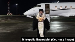 Episcopul Basarabiei de Sud, Veniamin, cu sfânta lumină, pe pista de aterizare a Aeroportului Internațional din Chișinău, pe 16 aprilie 2023, în ajunul Paștelui de anul trecut.