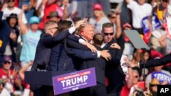Agjentët e Shërbimit Sekret duke larguar nga skena ish-presidentin Donald Trump. Pensilvani, 13 korrik 2024. 