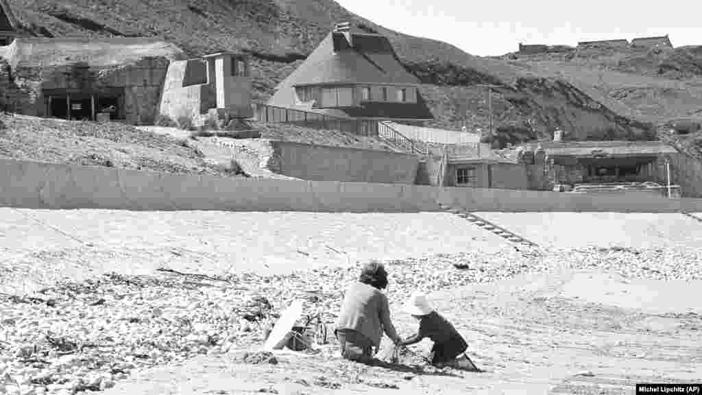 Francia gyerekek játszanak a vierville-sur-meri parton – amelyet Omaha Beach néven ismernek –, ahol még mindig állnak a német bunkerek 1964. június 6-án, húsz évvel a D-napi partraszállás után. Franciaország elnökeként eltöltött tizenegy éve alatt Charles de Gaulle nem vett részt a D-napi eseményeken. De Gaulle a világ vezetőit sem hívta meg a 25. évfordulóra 1969-ben