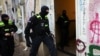 Një oficer i policisë gjermane duke hyrë në një ndërtesë apartamentesh gjatë një bastisjeje kundër njerëzve që mbështesin Hamasin. Berlin, 23 nëntor 2023.