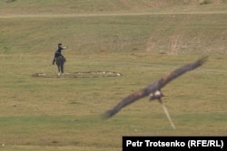 A bird is called to return to its hunter, who is waiting in a stone circle.