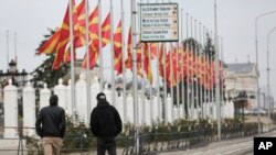 Kalimtarët duke kaluar rrugën afër ndërtesës së Qeverisë në Shkup. 