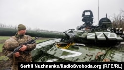 Український військовослужбовець біля пошкодженого російського танка Т-72БЗ під час масштабного вторгнення Росії до України. Ілюстративне фото