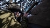 Український військовий спостерігає за активністю ворога на передовій позиції ЗСУ поблизу КПВВ «Гнутове», лютий 2020 року
