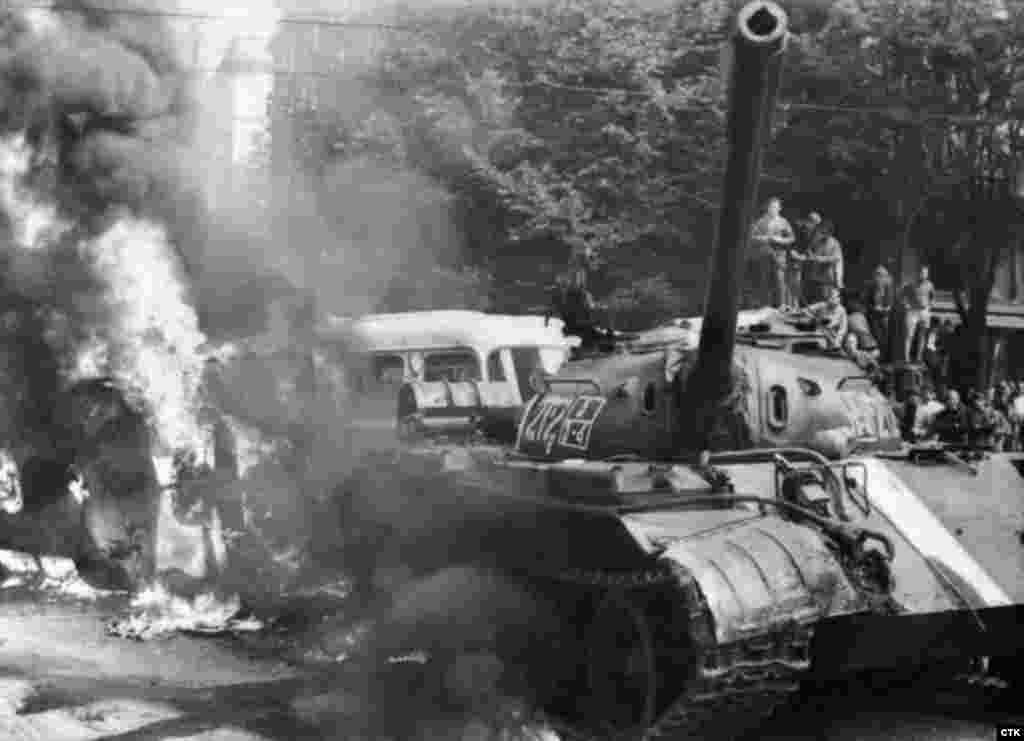 Un tanc sovietic în flăcări în apropierea sediului Radiodifuziunii cehe de la Praga.