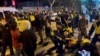 Polițiștii arestează protestatarii din Shanghai în timpul priveghiului cu lumânări pentru victimele incendiului din Urumqi