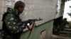Боец "Луганской народной республики" стреляет из жилых кварталов во время штурма управления луганского пограничного отряда