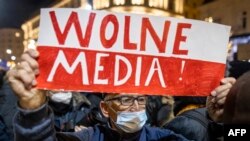 Tüntetés a sajtószabadságért és a TVN független médiavállalatot ellehetetlenítő törvény ellen Varsóban 2021. december 19-én. A plakáton a szabad média felirat látható.