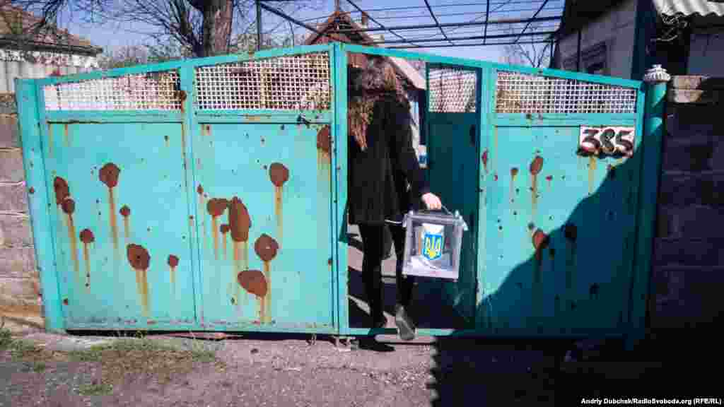Більшість будинків, де відбувається домашнє голосування, постраждали від обстрілів. Ворота посічені осколками, шибки вибиті...
