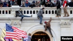 Mbështetësit e Donald Trumpit duke sulmuar ndërtesën e Kapitolit më 6 janar 2021. 