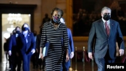 A vádat képviselő demokraták, Cheryl Jonsonnal és Tim Blodgett-tel az élen a Capitolium folyósóján sétálnak a Szenátus ülésterme felé kezükben a vádirattal. Washington főváros, Egyesült Államok, 2021. január 25.