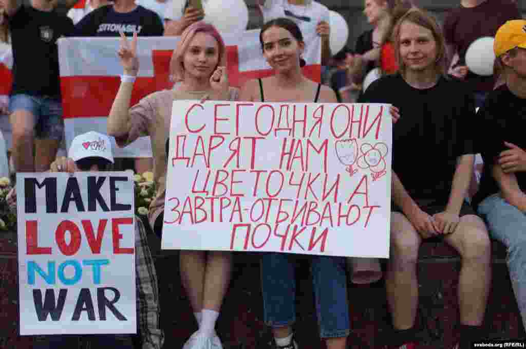 Femei din Belarus la un protest antiguvernamental în Homel, pe 16 august. Pe afiș scrie: „Astăzi ne dau flori. Mâine ne bat de ne sună apa."