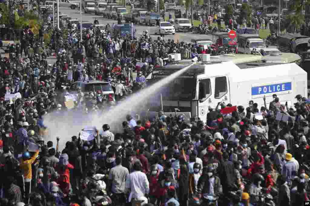 O mașină de poliție trage cu tunuri de apă înspre protestatarii din Naypyitaw, Myanmar. Imagine surprinsă în data de 8 februarie.