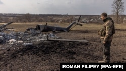 Український військовий стоїть біля збитого російського літака, Харківська область, березень 2022 року 