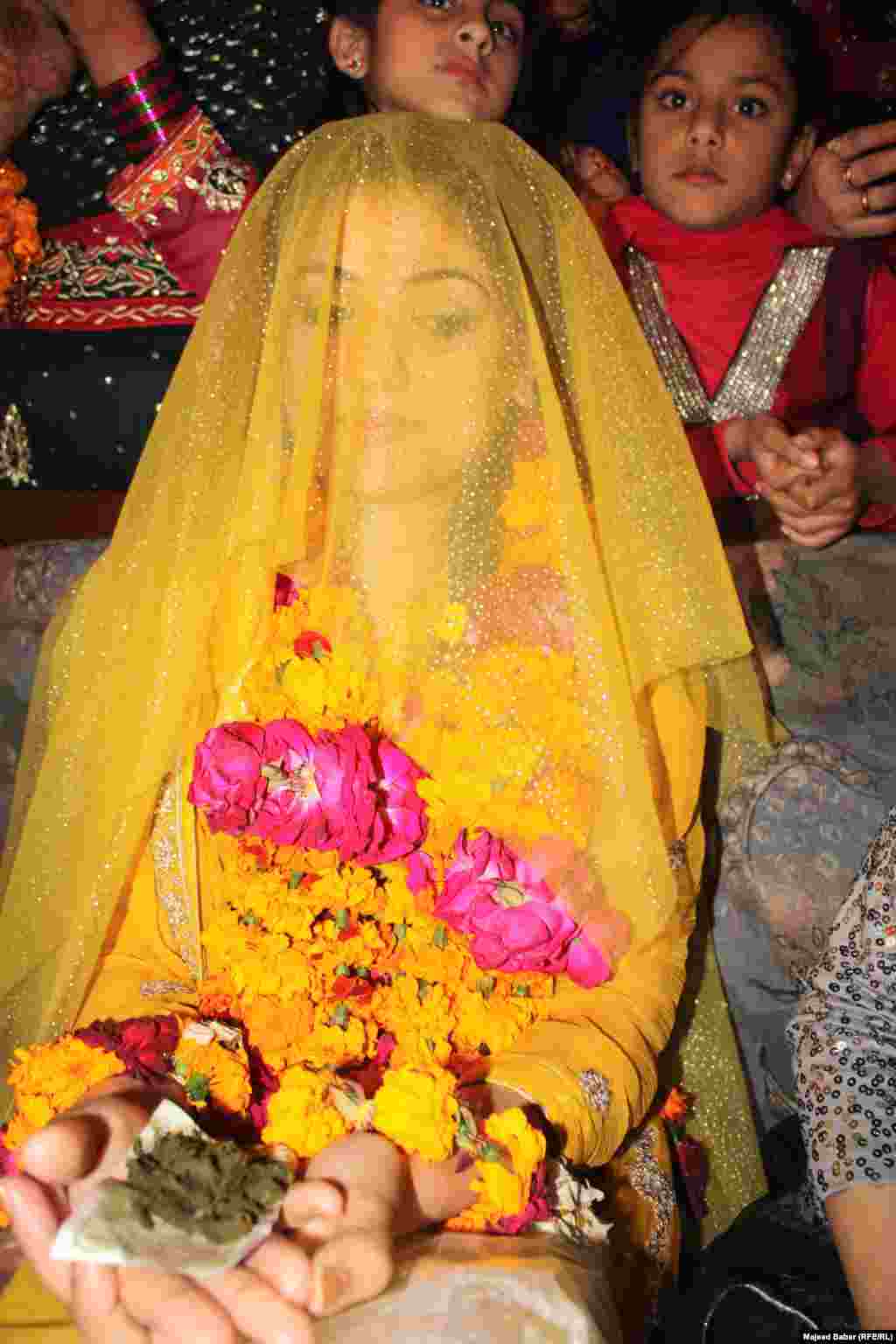 Holding currency laced with henna symbolizes hopes that the bride will have a prosperous life.
