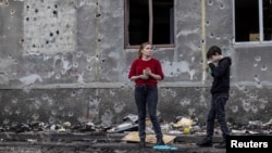 Urme de schije pe zidul unei clădiri din orașul ucrainean Dobropilla, scena unui bombardament rusesc cu rachete, din 8 martie