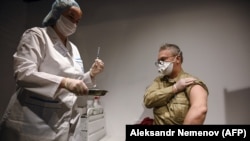Un bărbat primind vaccinul Sputnik V la punctul medical de la Magazinul universal GUM. 18 ianuarie 2021