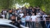 Emberek várakoznak a kazanyi 175-ös számú iskola közelében, ahol legalább egy tanár és hét diák vesztette életét, többen pedig megsérültek egy lövöldözés során, 2021. május 11-én.