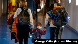 ROMANIA - O familie purtând măști chirurgicale, pe aeroportul Otopeni din Bucuresti