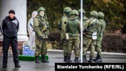 Эн белгисиз орусиялык жоокерлер ("жашыл кишилер") Симферополдогу аба майданды көзөмөлдөп турат. 2014-жылдын 28-февралы.