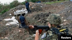 Украинские военные проверяют позиции в районе деревни Семеновка под Славянском, 14 июля 2014 года.