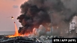 LEBANON - A helicopter puts out a fire at the scene of an explosion at the port of Lebanon's capital Beirut on August 4, 2020.