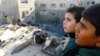 Palestinska djeca gledaju na štetu na mjestu izraelskih udara na kuće, usred tekućeg sukoba između Izraela i Hamasa, u Khan Younisu u južnom pojasu Gaze, 10. decembra 2023.