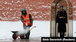 Un muncitor presoară sare în fața zidului Kremlinului