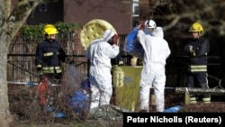 Officials in protective suits near the park bench where Sergei Skripal and his daughter Yulia were found poisoned