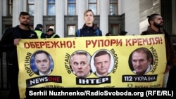 Aktivisták a Verkhovna Rada előtt az ukrán információs tér védelmét követelik „az orosz információs agresszióval szemben”. A molinón Firtas és Medvedcsuk neve is szerepel. Kijev, 2018. október 4.