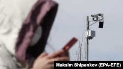 Žena prolazi pored CCTV kamere dok gleda u svoj mobitel, Moskva