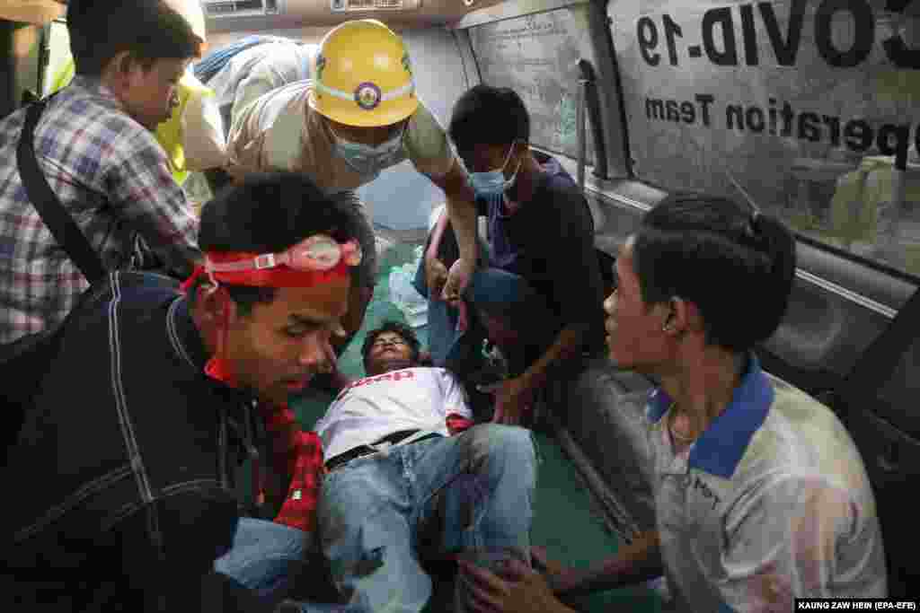 Un bărbat rănit este transportat într-o ambulanță de către personalul medical după ce poliția a tras asupra manifestanților în timpul unui protest împotriva puciului. Mandalay, Myanmar, 20 februarie 2021. (Foto: Kaung ZAW HEIN / EPA-EFE )