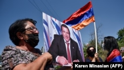 ARMENIA -- A supporter of Armenian opposition leader Gagik Tsarukian holds its portrait during a unauthorized rally close to National Secuirury Service headquarter in Yerevan, June 14, 2020