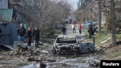 Banorët e Dnipros inspektojnë pasojat e një sulmi rus në qytetin ukrainas natën e 28 marsit.