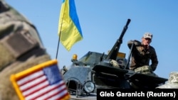 Një instruktor ushtarak i ushtrisë amerikane shihet pranë ushtarakëve ukrainas gjatë stërvitjeve shumëkombëshe "Rapid Trident 2019" në Qendrën Ndërkombëtare të Paqes dhe Sigurisë pranë Lviv, 24 shtator 2019.