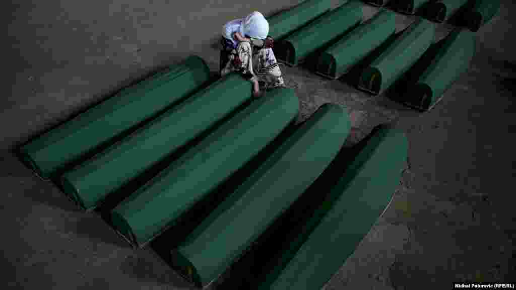 O femeie plânge lângă sicriul unei victime a masacrului din Srebrenica, din 1995, din Bosnia și Herțegovina, după ce 35 de victime recent identificate au fost înmormântate la cimitirul Potocari. Forțele sârbe bosniace care au atacat orașul Srebrenica în iulie 1995 au ucis aproximativ 8.000 de băieți și bărbați musulmani. (Midhat Poturovic, RFE/RL)