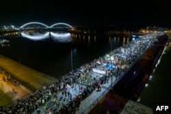 Mii de manifestanți sârbi au marcat trei luni de la prăbușirea fatală a acoperișului de beton al unei gări din Novi Sad prin blocarea a trei poduri din oraș, 31 ianuarie 2025.