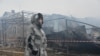 O localnică din Harkov trece prin fața casei vecinilor ei, distrusă de un atac cu drone la Harkov, pe 25 decembrie.