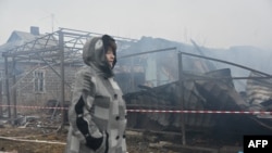 O localnică din Harkov trece prin fața casei vecinilor ei, distrusă de un atac cu drone la Harkov, pe 25 decembrie.