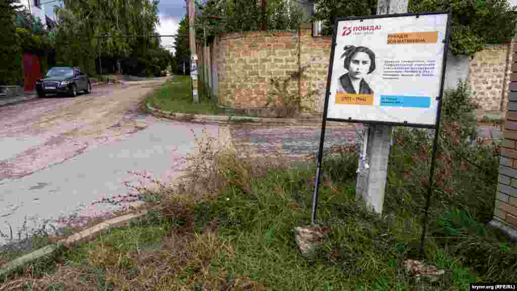 Щит з інформацією про Зою Рухадзе, встановлений торік на вулиці, названій на її честь, хтось викопав і притулив до стовпа. Дівчина – учасниця сімферопольського підпілля в роки німецько-румунської окупації під час Другої світової війни. Замордована в гестапівських катівнях. Посмертно нагороджена медаллю «За відвагу»