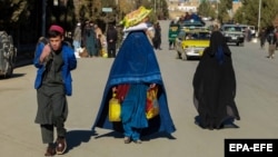 Afghan families receive food aid distributed by the German government in Kabul.