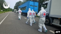 Anëtarët e Kryqit të Kuq gjatë operacionit të riatdhesimit të ushtarëve të vrarë ukrainas. 11 qershor 2025. 