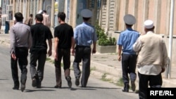 Polisiýa işgärleri bilen graždan adamlar metjide barýarlar, Duşenbe, Täjigistan. 